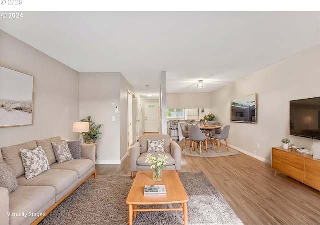 29650 SW Courtside Dr Unit 18, Wilsonville, OR 97070 - living room featuring baseboards and light wood-type flooring