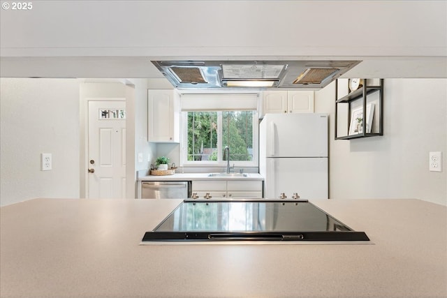 29650 SW Courtside Dr Unit 18, Wilsonville, OR 97070 - kitchen featuring freestanding refrigerator, a sink, white cabinetry, stainless steel dishwasher, and light countertops