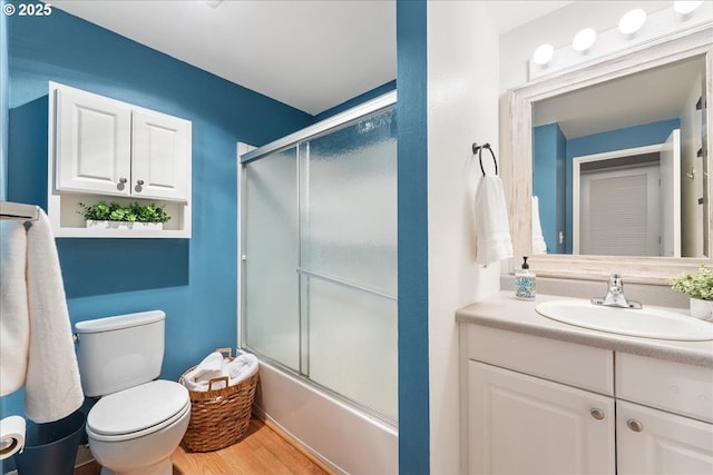 29650 SW Courtside Dr Unit 18, Wilsonville, OR 97070 - bathroom with vanity, shower / bath combination with glass door, toilet, and wood finished floors