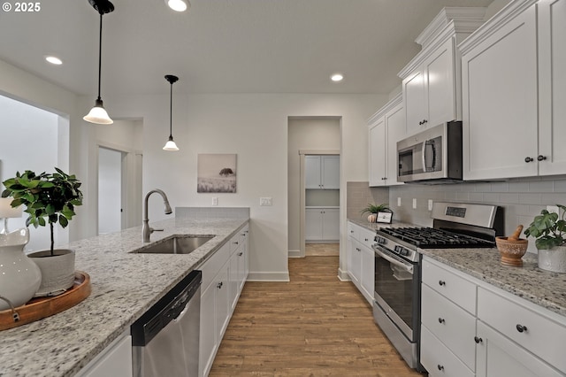 5316 SE Lone Oak St, Hillsboro, OR 97123 - kitchen featuring white cabinets, wood finished floors, a sink, stainless steel appliances, and backsplash