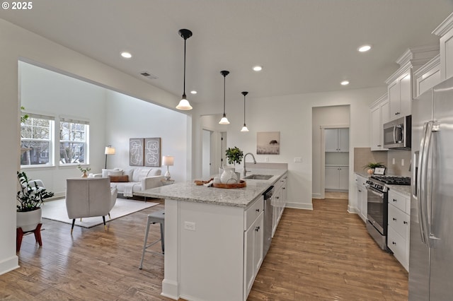 5316 SE Lone Oak St, Hillsboro, OR 97123 - kitchen featuring visible vents, a sink, a kitchen bar, white cabinetry, and stainless steel appliances