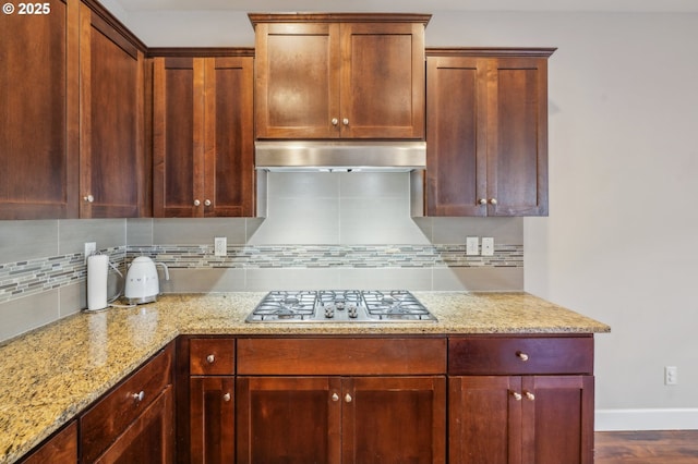 kitchen featuring light stone counters, wood-type flooring, stainless steel gas cooktop, and decorative backsplash