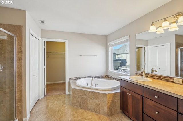 bathroom with vanity, tasteful backsplash, and independent shower and bath