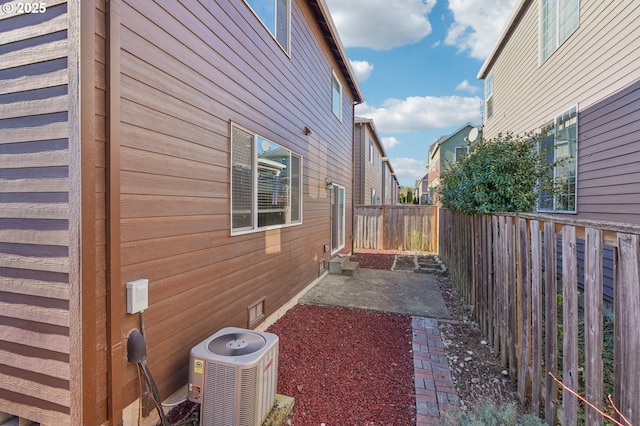 view of side of property with central AC unit and a patio area