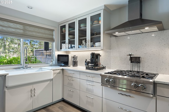240 Greenridge Dr, Lake Oswego, OR 97035 - kitchen featuring wall chimney range hood, stainless steel gas cooktop, tasteful backsplash, glass insert cabinets, and wood finished floors