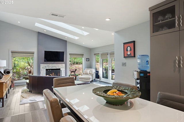 240 Greenridge Dr, Lake Oswego, OR 97035 - dining room with vaulted ceiling, a high end fireplace, a skylight, light wood-style floors, and recessed lighting