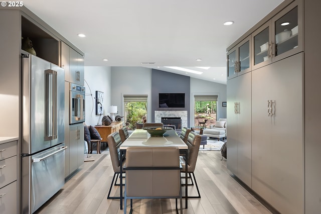 240 Greenridge Dr, Lake Oswego, OR 97035 - dining space with a high end fireplace, vaulted ceiling, light wood finished floors, and recessed lighting