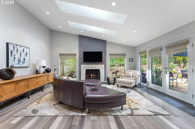 240 Greenridge Dr, Lake Oswego, OR 97035 - living room with vaulted ceiling, wood finished floors, a fireplace, a skylight, and french doors