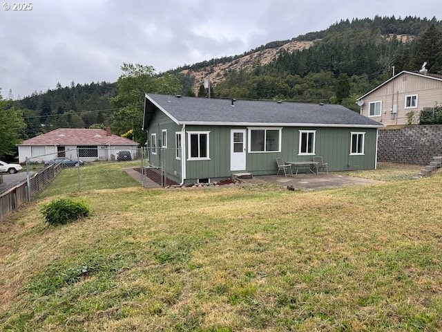 847 NE Jackson Ave, Myrtle Creek, OR 97457 - back of house with a mountain view, a patio area, a forest view, and board and batten siding
