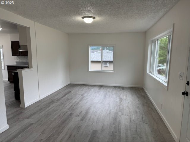 847 NE Jackson Ave, Myrtle Creek, OR 97457 - unfurnished dining area with wood finished floors, a textured ceiling, and baseboards