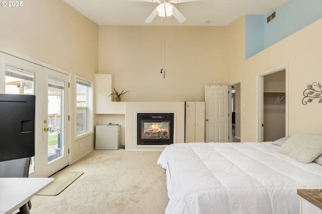 1273 SE Williams Ave, Gresham, OR 97080 - carpeted bedroom with a glass covered fireplace, access to exterior, visible vents, and a towering ceiling