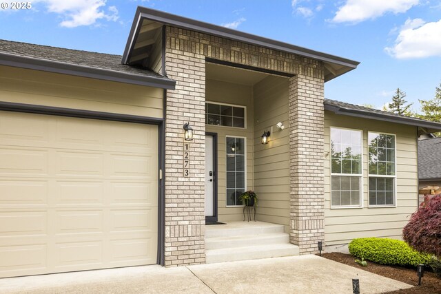 1273 SE Williams Ave, Gresham, OR 97080 - property entrance featuring an attached garage, driveway, and brick siding