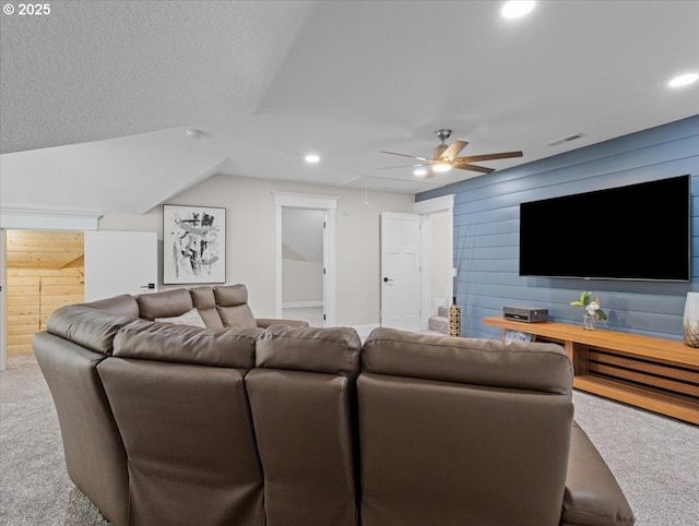 home theater with carpet floors, a textured ceiling, ceiling fan, and wood walls