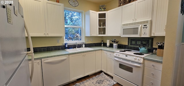 kitchen with white cabinetry, sink, dark wood-type flooring, and white appliances