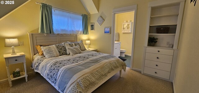 bedroom with connected bathroom and dark carpet