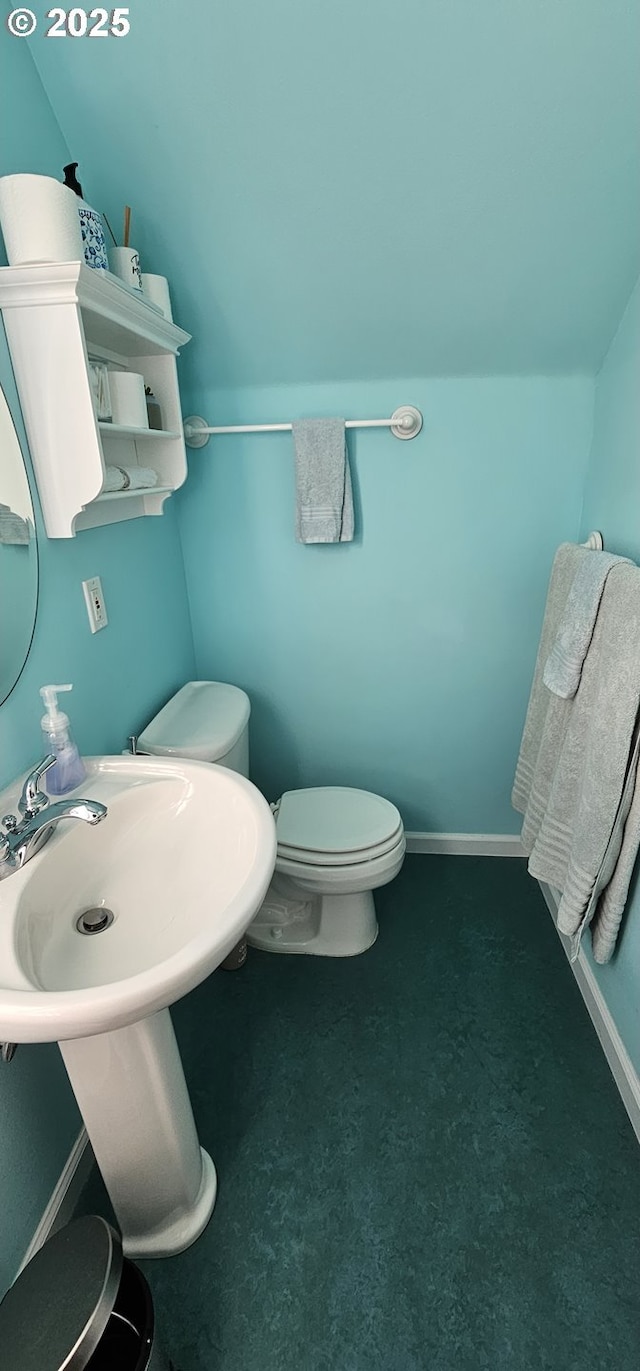 bathroom with lofted ceiling and toilet