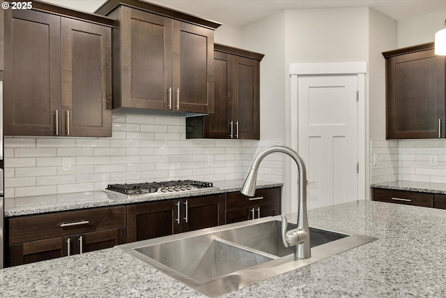 1059 S Walnut St, Canby, OR 97013 - kitchen with a sink, stainless steel gas stovetop, decorative backsplash, dark brown cabinets, and light stone countertops