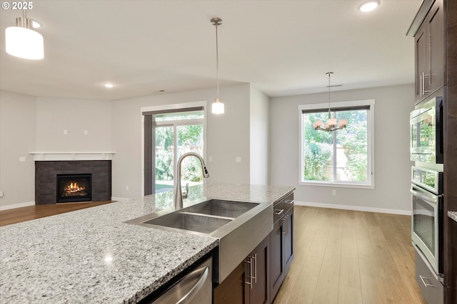 1059 S Walnut St, Canby, OR 97013 - kitchen with appliances with stainless steel finishes, a sink, light wood finished floors, light stone countertops, and recessed lighting