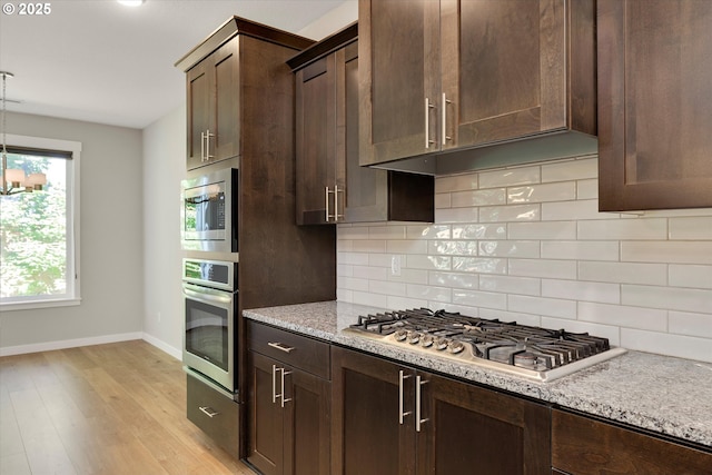 1059 S Walnut St, Canby, OR 97013 - kitchen featuring appliances with stainless steel finishes, baseboards, and dark brown cabinetry