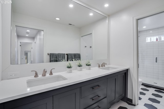 bathroom featuring a shower with door, vanity, and toilet