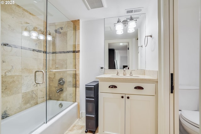 full bathroom with enclosed tub / shower combo, vanity, and toilet