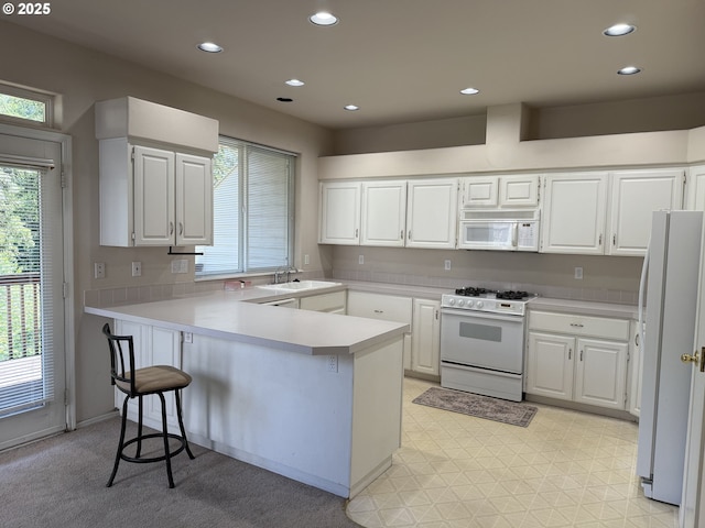 15680 SW Talus Way, Beaverton, OR 97007 - kitchen with white appliances, a peninsula, plenty of natural light, white cabinets, and recessed lighting