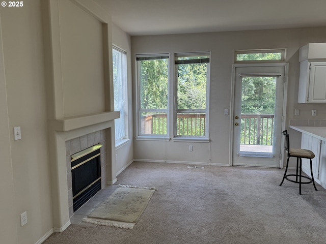 15680 SW Talus Way, Beaverton, OR 97007 - unfurnished living room with light colored carpet, a tiled fireplace, and baseboards