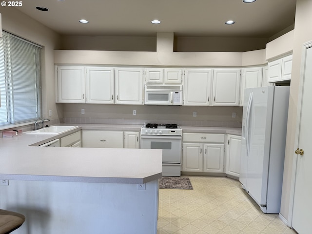 15680 SW Talus Way, Beaverton, OR 97007 - kitchen with white appliances, a sink, light floors, a peninsula, and light countertops
