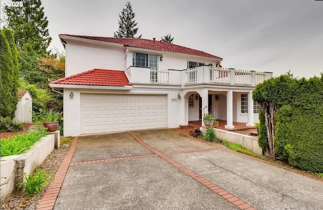 5706 SW Hamilton St, Portland, OR 97221 - mediterranean / spanish home featuring a balcony, a tiled roof, driveway, stucco siding, and a porch