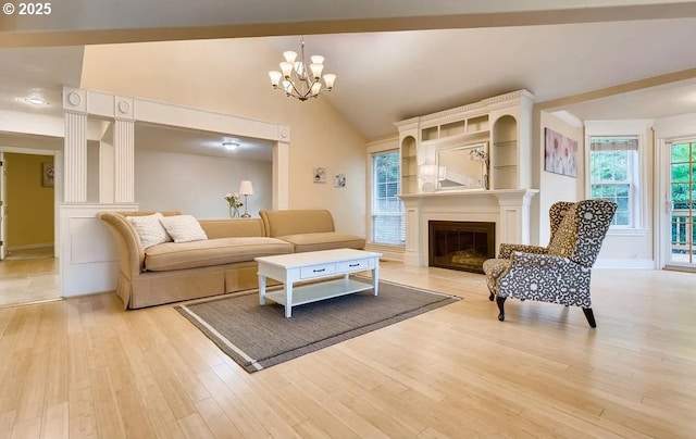 5706 SW Hamilton St, Portland, OR 97221 - living room with a chandelier, light wood-type flooring, a glass covered fireplace, and lofted ceiling