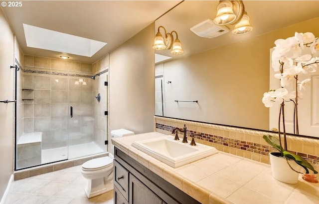 5706 SW Hamilton St, Portland, OR 97221 - bathroom featuring vanity, backsplash, a stall shower, tile patterned floors, and a skylight