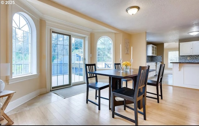5706 SW Hamilton St, Portland, OR 97221 - dining area with a textured ceiling, light wood-style flooring, and ornamental molding