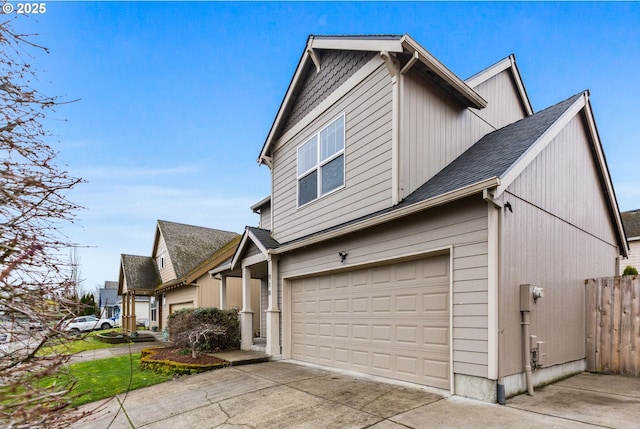 view of home's exterior featuring driveway, an attached garage, and fence