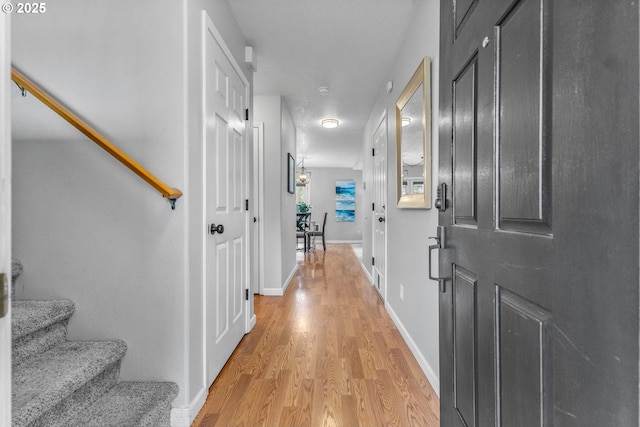 interior space featuring stairway, light wood-style flooring, and baseboards