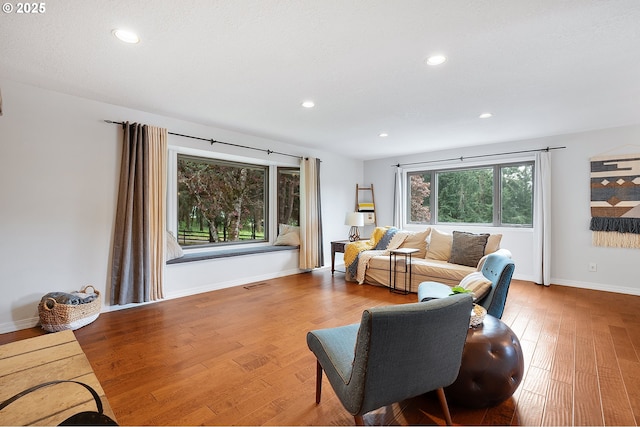 living area featuring baseboards, recessed lighting, wood finished floors, and visible vents