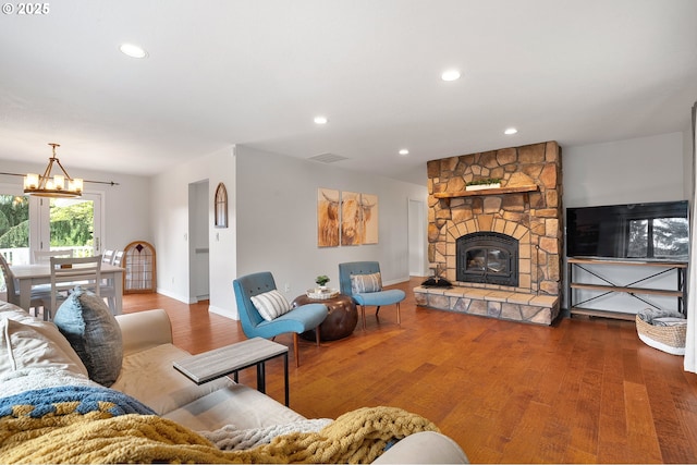 living area with baseboards, recessed lighting, wood finished floors, and an inviting chandelier