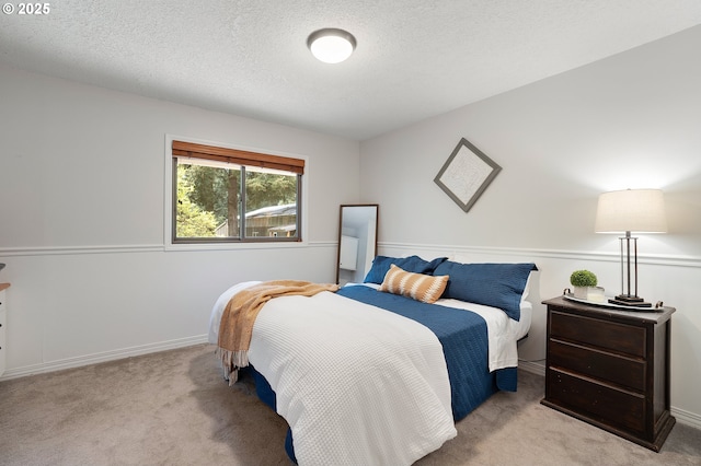 bedroom with baseboards, carpet flooring, and a textured ceiling