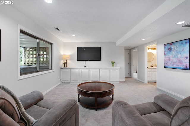 living room featuring recessed lighting, a textured ceiling, visible vents, and light carpet