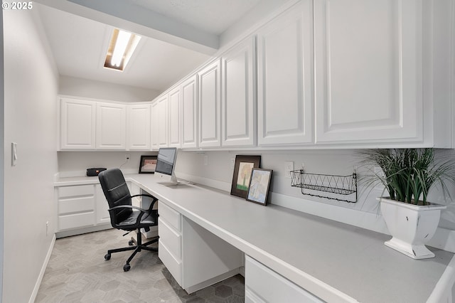office area featuring baseboards and built in desk