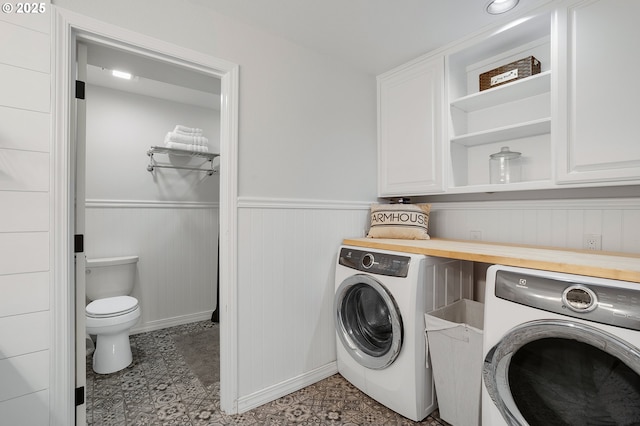 washroom featuring baseboards, wainscoting, and washer and dryer
