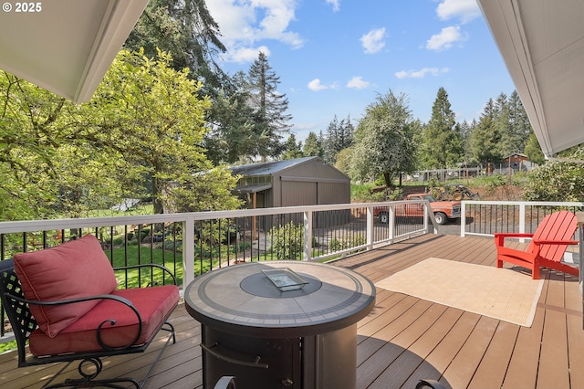 wooden deck featuring a storage shed and an outbuilding