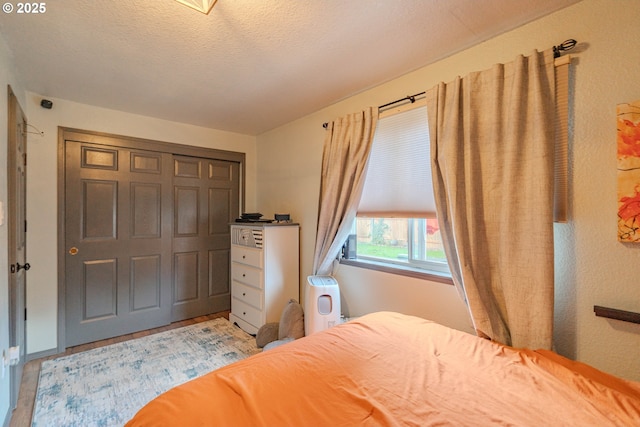 bedroom with light wood finished floors and a textured ceiling