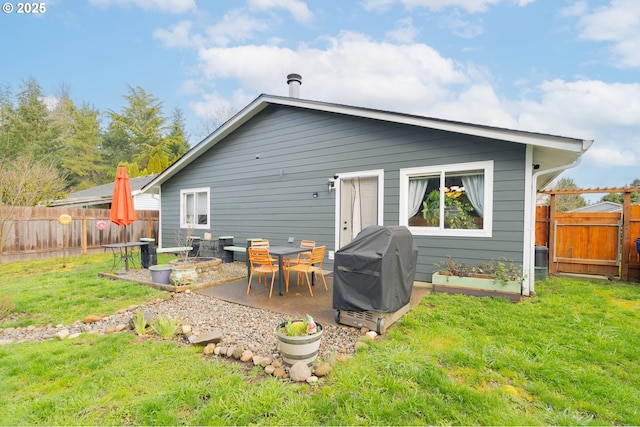 back of house featuring a yard, a fenced backyard, and a patio area