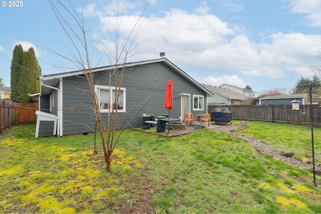 rear view of house with a patio area, a lawn, and a fenced backyard