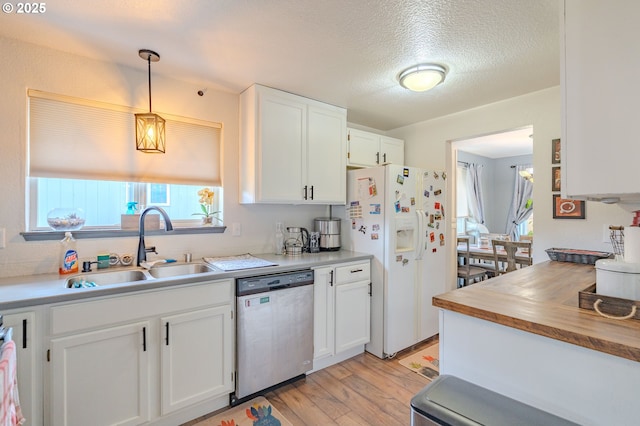 kitchen featuring light wood finished floors, a sink, white cabinets, white fridge with ice dispenser, and dishwasher