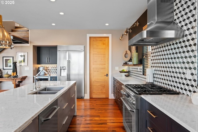 23586 NW St Helens Rd Unit U12, Portland, OR 97231 - kitchen with high quality appliances, wall chimney range hood, a sink, dark wood-style floors, and backsplash