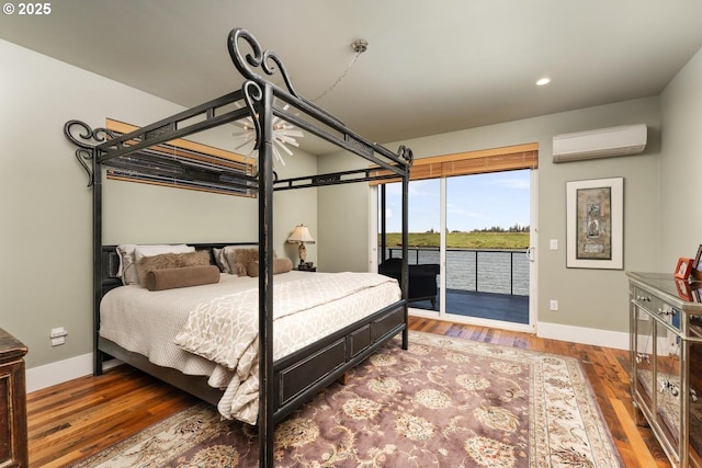 23586 NW St Helens Rd Unit U12, Portland, OR 97231 - bedroom featuring a wall unit AC, access to exterior, baseboards, wood finished floors, and recessed lighting