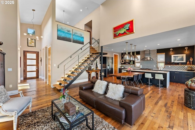 23586 NW St Helens Rd Unit U12, Portland, OR 97231 - living room featuring a towering ceiling, light wood-style floors, stairway, and baseboards