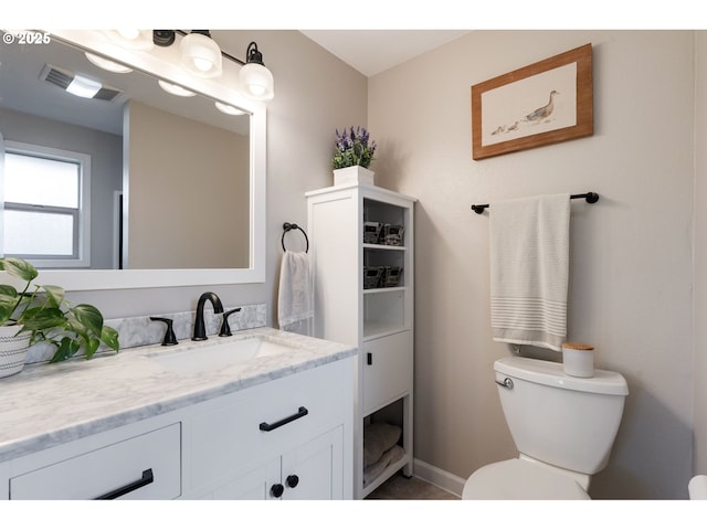 bathroom featuring toilet, baseboards, visible vents, and vanity