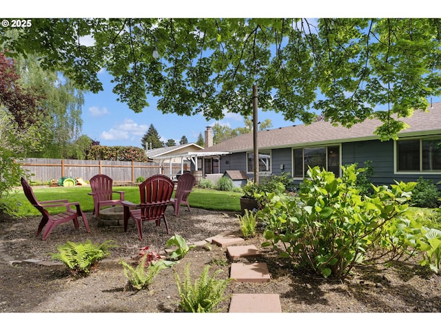 view of yard with fence and a fire pit